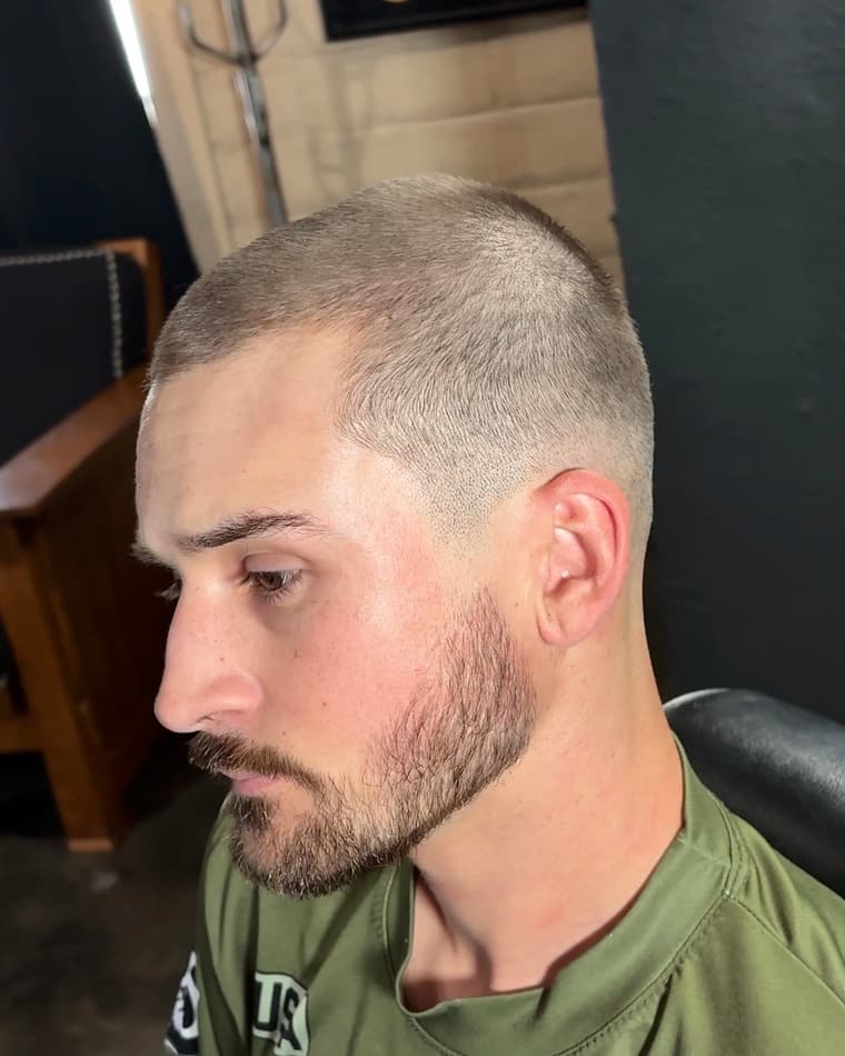 Close buzz cut with a skin fade through the sides and a lined beard.
