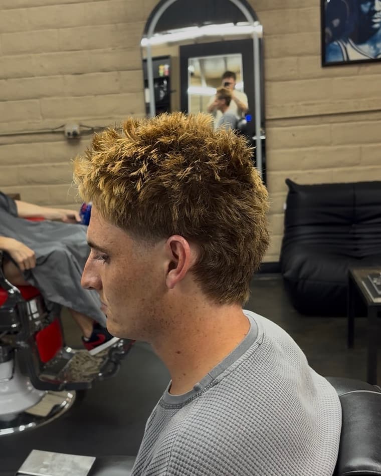 Blonde textured curls over a clean mid fade.